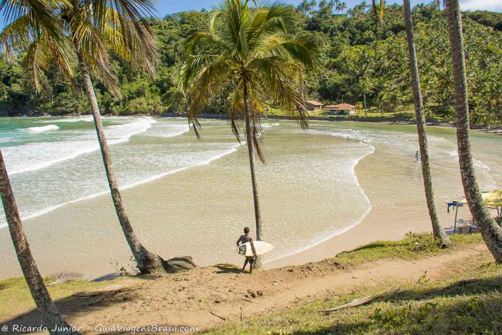 Imagem de um menino chegando com sua pracha na Praia de Jeribucaçu.